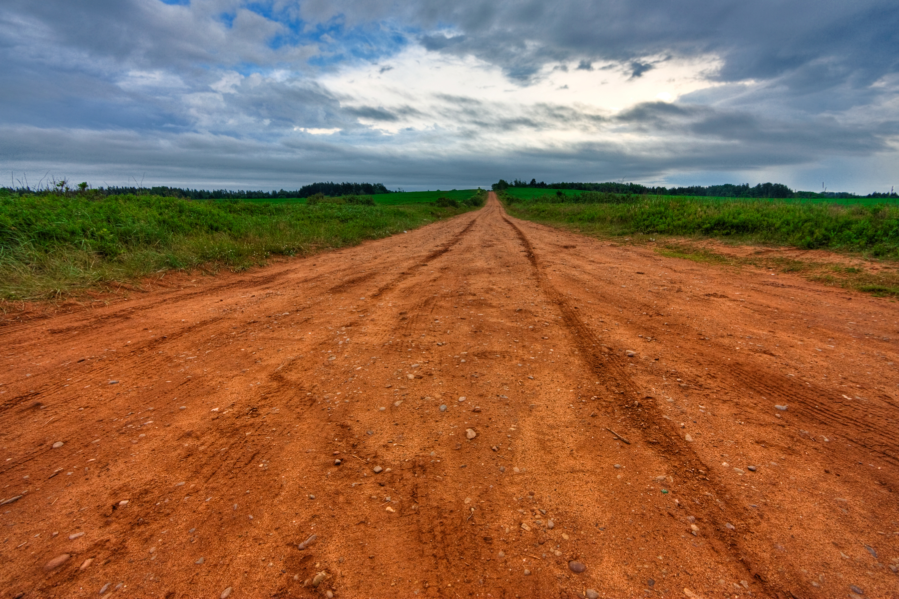 Red dirt road through Prince Edward Island farm fields
